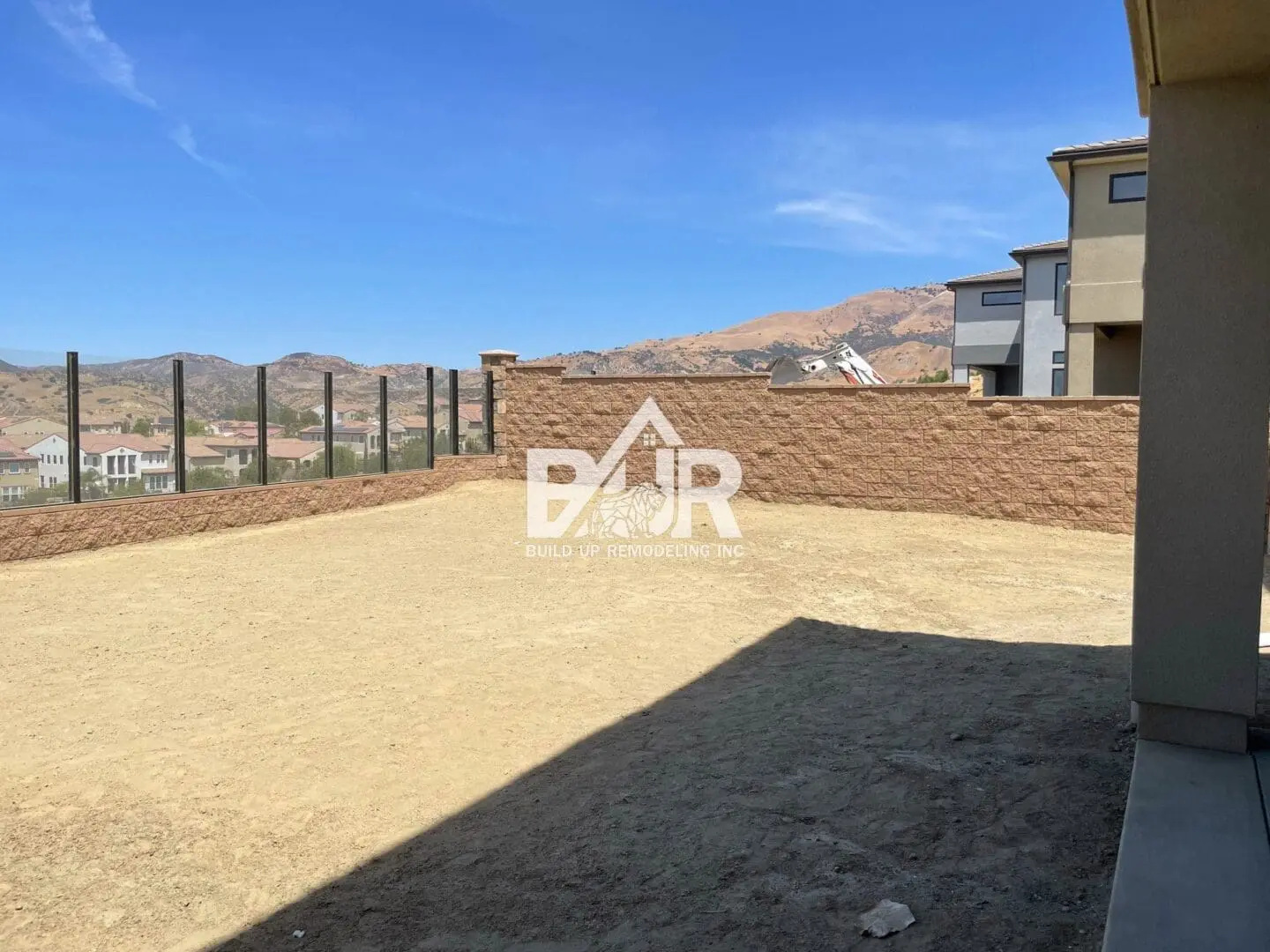 Spacious outdoor area with beige ground and clear blue sky.