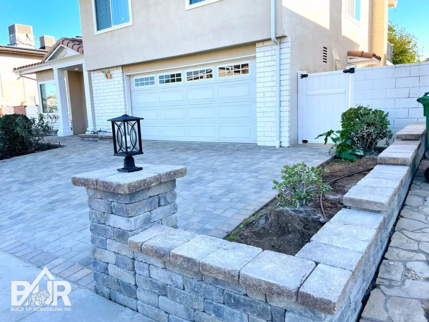 Modern house with paved driveway and lantern.