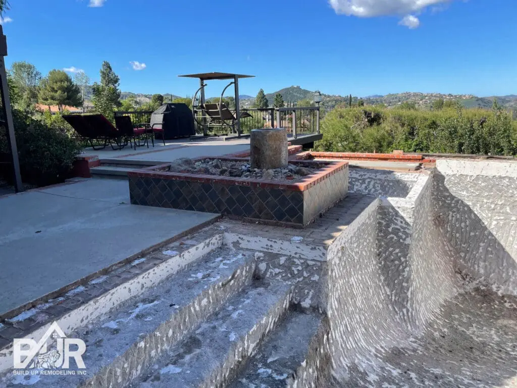 Empty pool with patio and scenic view.