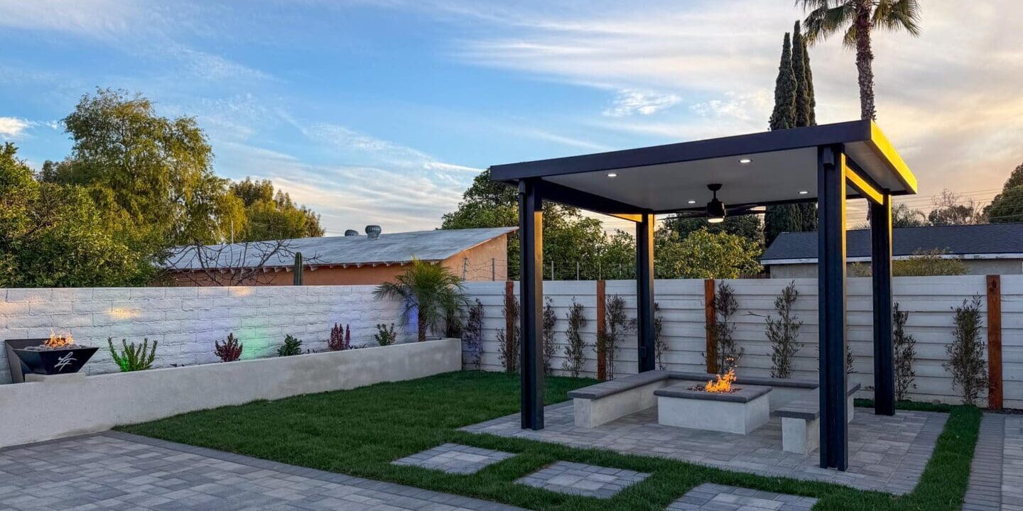Modern backyard patio with fire pit and pergola.