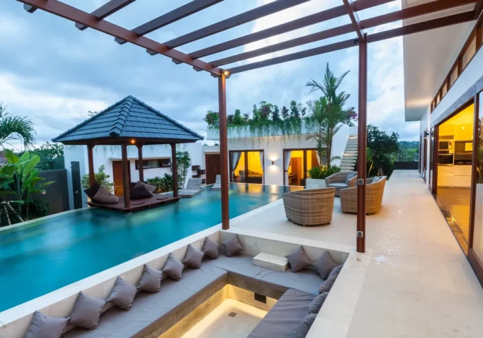 Luxurious poolside villa with outdoor seating area.