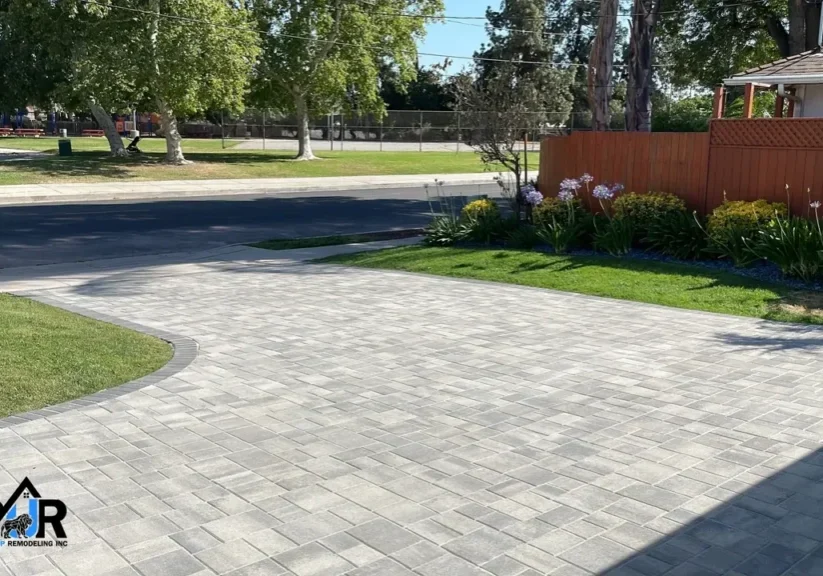 Paved driveway with surrounding greenery and trees.